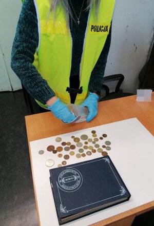 Policjantka przelicza odzyskane monety kolekcjonerskie