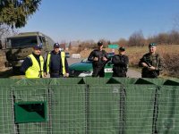 Policjanci, funkcjonariusze straży granicznej i żołnierz pilnują zamkniętego przejścia granicznego w Jarnołtówku