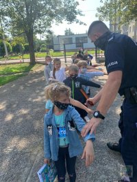 Policjanci uczą dzieci jak prawidłowo przejść przez jezdnię