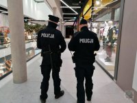 Dwóch umundurowanych policjantów kontroluje galerię handlową