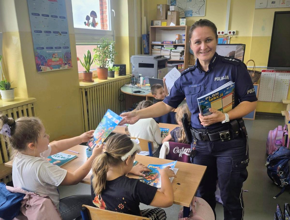 policjantka rozdająca książeczkę