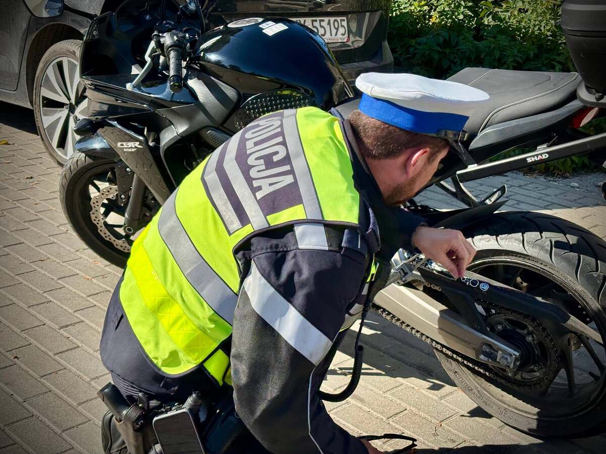 policjant kontrolujący motocykl 