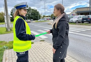policjantka daje kobiecie odblask