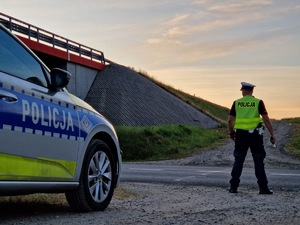 Na zdjęciu znajduje się stojący tyłem policjant Wydziału Ruchu Drogowego podczas kontroli trzeźwości.