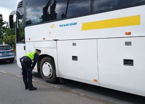 Kolorowa grafika - policjant podczas kontroli autokaru.