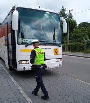 Kolorowa grafika - policjant podczas kontroli autokaru.