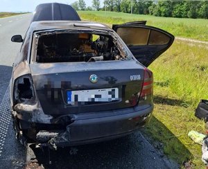 kolorowe zdjęcia - na zdjęciu na drodze znajduje się pojazd, który został zniszczony w wyniku powstania pożaru.