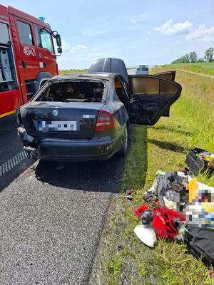 kolorowe zdjęcia - na zdjęciu na drodze znajduje się pojazd, który został zniszczony w wyniku powstania pożaru.