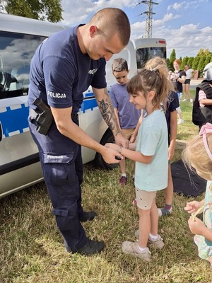 Kolorowe zdjęcie - policjant podczas spotkania  dziećmi.