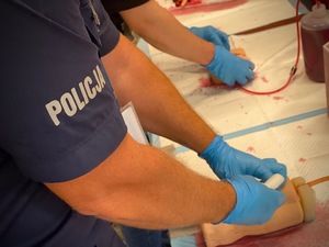 kolorowa grafika - funkcjonariusze podczas ćwiczeń na trenażerach tamowania krwotoków